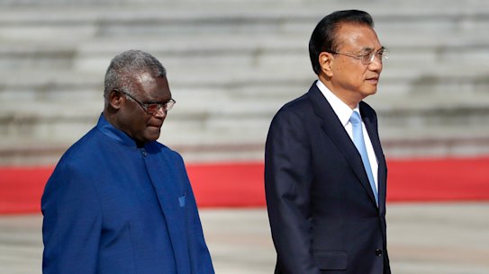 Solomon Islands Prime Minister Manasseh Sogavare, left, walks with Chinese Premier Li Keqiang in October 2019. 