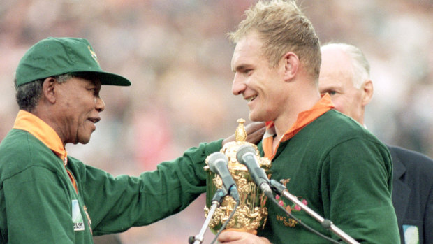Nelson Mandela hands South African captain Francois Pienaar the Webb Ellis Trophy.