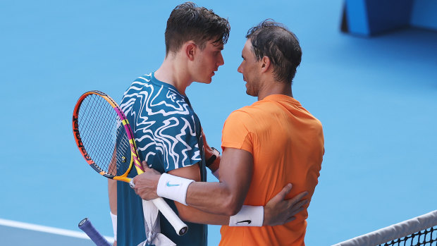 Jack Draper and Rafael Nadal embrace at the net.