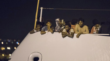 Migrants wait to disembark from Frontex ship "Protector" at the port of Pozzallo, Sicily, Italy, after a half-dozen European countries promised to take some of them.