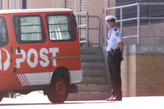 Australian Federal police Officers stand gaurd outside the Fyshwick Mail Sorting Centre in Canberra.