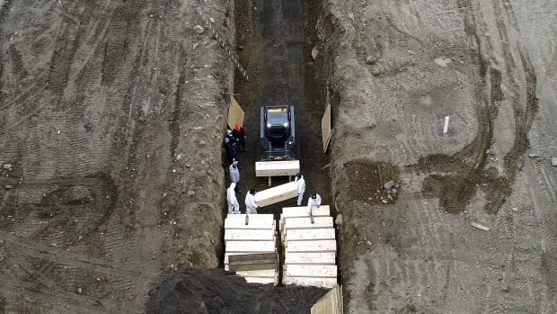 Workers bury COVID-19 victims in a trench on Hart Island, New York, in April.