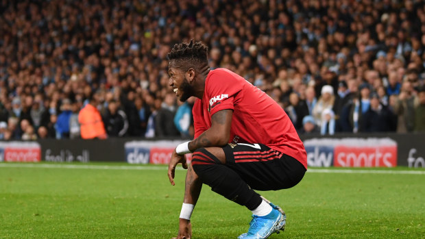 Fred of Manchester United reacts after being hit by a lighter thrown from the crowd at Etihad Stadium.