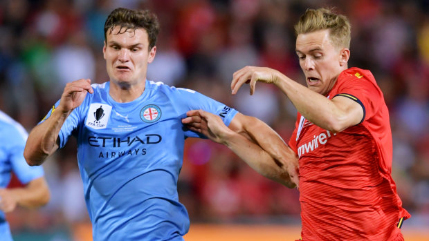Melbourne City's Curtis Good competes with Adelaide United's Kristian Opseth.