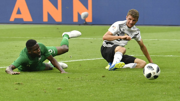 Saudi Arabia's Omar Hawsawi, left, scores own goal as Germany's Thomas Muller celebrates.