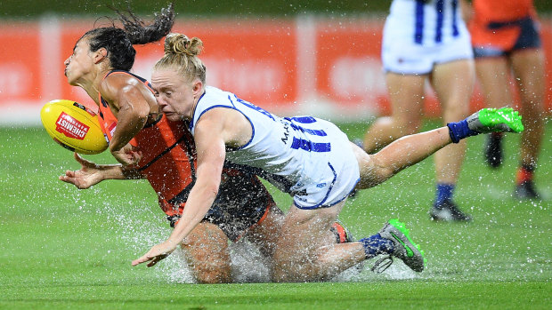 Wet and wild: Amanda Farrugia of the Giants is tackled by Emma Humphries of the Kangaroos. 