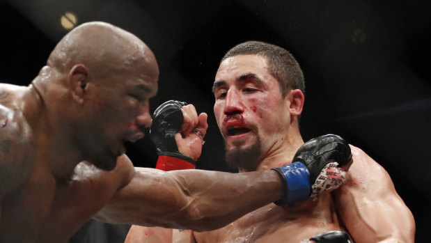 Bloodied: Rob Whittaker takes a blow during his bout with Yoel Romero. 
