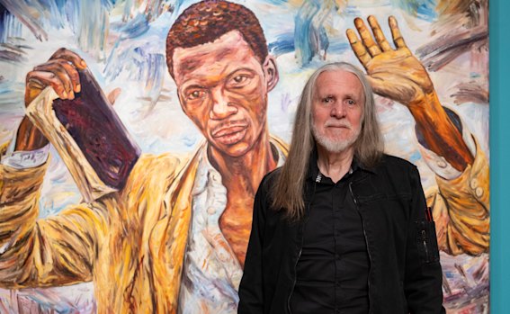 George Gittoes with his painting of a preacher during the Rwandan massacre that has gone on display at the National Gallery.