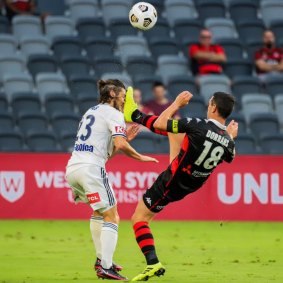 Victory’s Marco Rojas is caught high by Wanderers skipper Graham Dorrans.