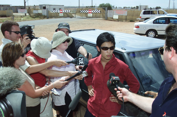 Hassan, as a lawyer representing detainees, speaks outside the gates of the immigration detention facility in Woomera, South Australia, in 2002.