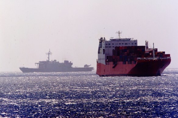 An Australian navy ship passes by the MV Tampa off Christmas Island.