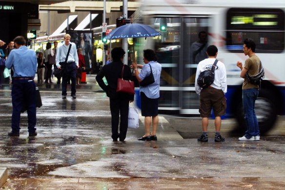 Waiting for a bus in the rain.