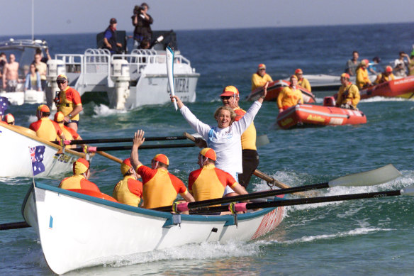 Miley-Dyer holds the Olympic torch aloft at Bondi Beach in 2000. 