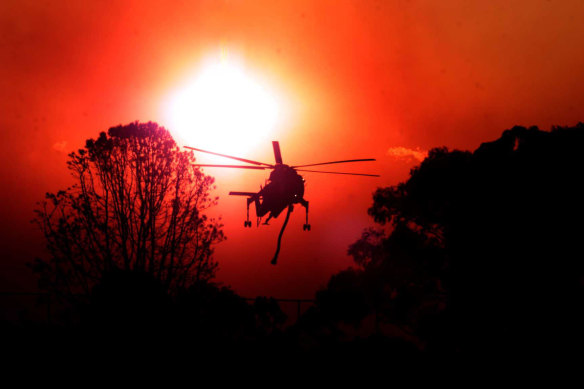 The helicopter, dubbed Elvis, working against in a blood-red sky in Macquarie Park.