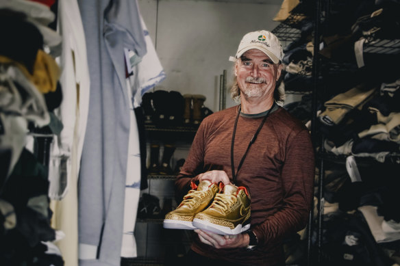 James Free posing for a photo with a pair of of gold Nike Air Jordan 3 sneakers at the Portland Rescue Mission.