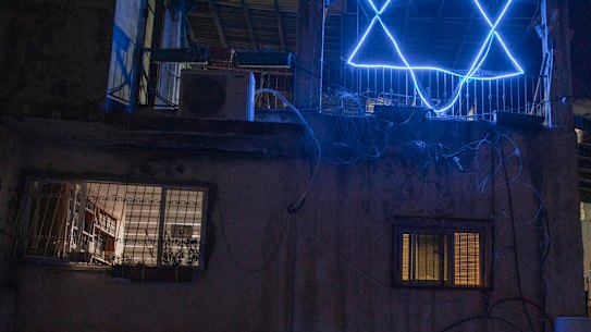 Nasser Rajabi and his mother, in the doorway below, share a house in East Jerusalem with Jewish settlers.