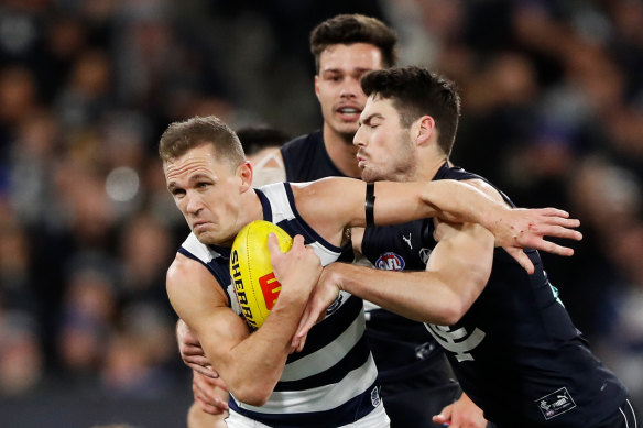 Joel Selwood is tackled by George Hewett.