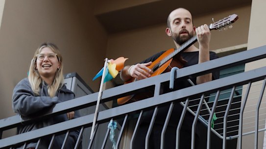 A man plays guitar on the balcony of his home during a flash mob launched throughout Italy to bring people together and try to cope with the emergency of coronavirus, in Milan, Italy on Friday.