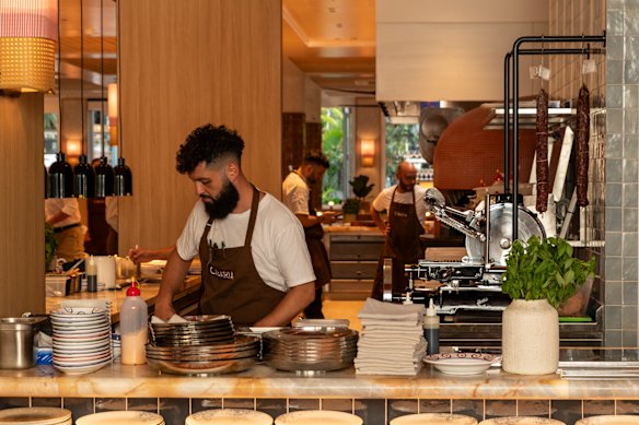 A sala de jantar principal está organizada em torno de uma cozinha aberta com grandes bancadas baixas.