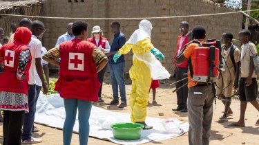Volunteers get into protective clothing while dealing with multiple outbreaks in the Congo.