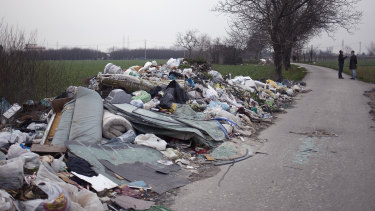 Environmental activists Leopoldo Esposito and Ciro Tufano survey farmland littered with a mix of household and industrial waste near Marigliano, north of Naples in Italy, in 2014. 