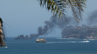 A boat is on fire on Sydney Harbour, as seen from Fairlight.