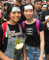 Heather and Ariel carried white flowers in memory of the protester who died in Hong Kong on Saturday. 