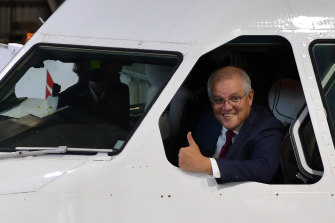 Prime Minister Scott Morrison leaning out of a Qantas plane on Thursday ahead of announcing the $1.2 billion industry package. 