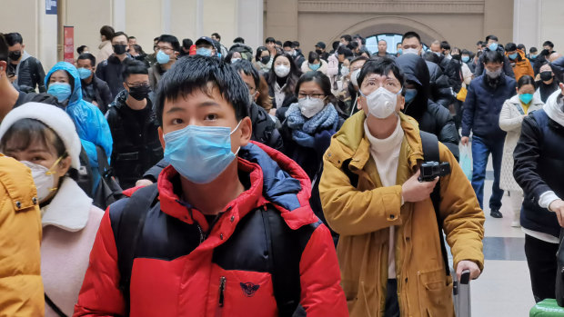 People wear face masks as they wait at Hankou Railway Station in Wuhan last week. 