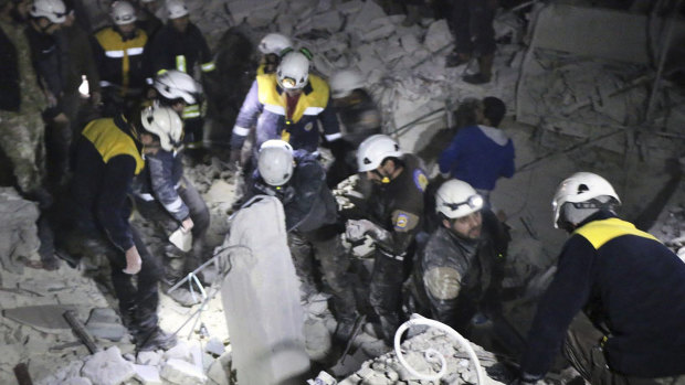 Syrian Civil Defence White Helmets inspect a damaged building after an attack in July.