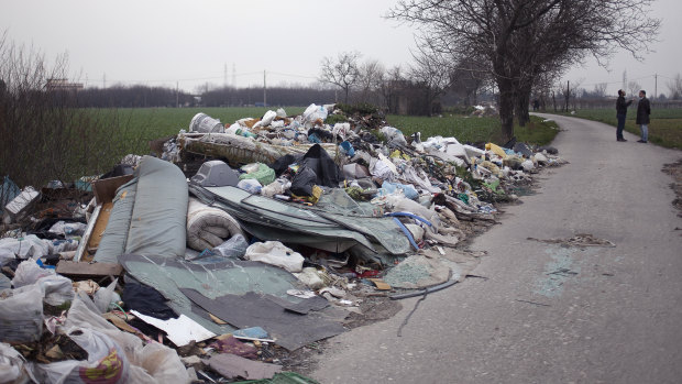 Environmental activists Leopoldo Esposito and Ciro Tufano survey farmland littered with a mix of household and industrial waste near Marigliano, north of Naples in Italy, in 2014. 