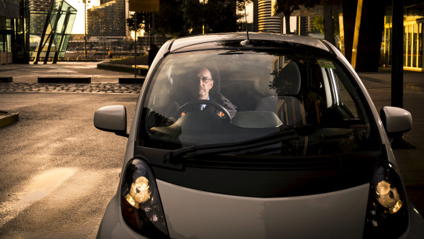 Electric car owner Daryl Budgeon in his 2012 Mitsubishi i-Miev.