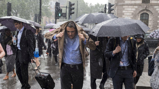 People walk through the rain in the Westminster area of London in torrential rains in 2016.
