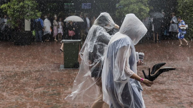 Thousands of racegoers faced torrential rain for the start of the Melbourne Cup races.