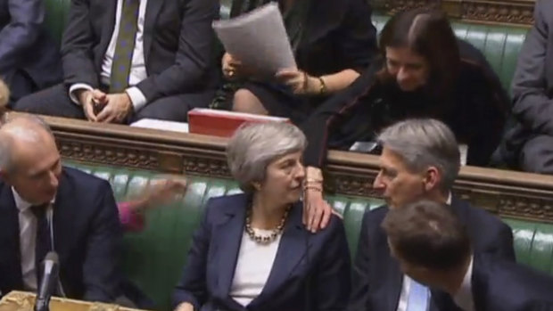Theresa May is congratulated by Conservative Party ministers in the House of Commons after speaking at the start of a five-day debate on Brexit.