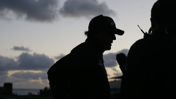 Phil Mickelson talks with reporters at Pebble Beach after play was halted for the second time.