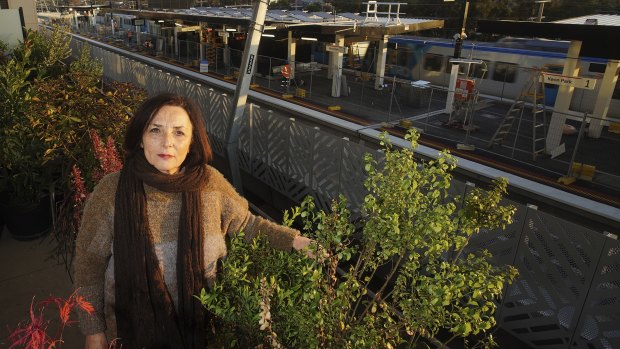 Angela Villella on her balcony as a train passes through the station.