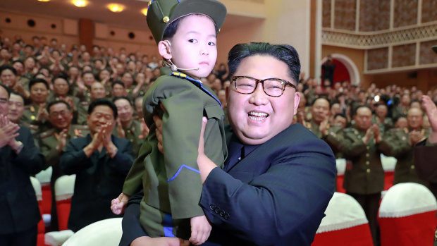 North Korean leader Kim Jong-un holds a boy during a musical performance in this photo provided by the North Korean government. 