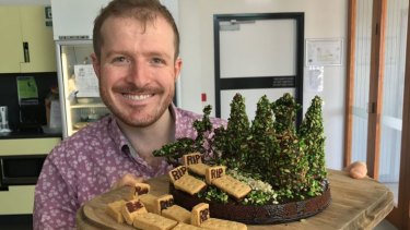 Dr Matthew Holden with a cake he baked to reflect his conservation burial research.