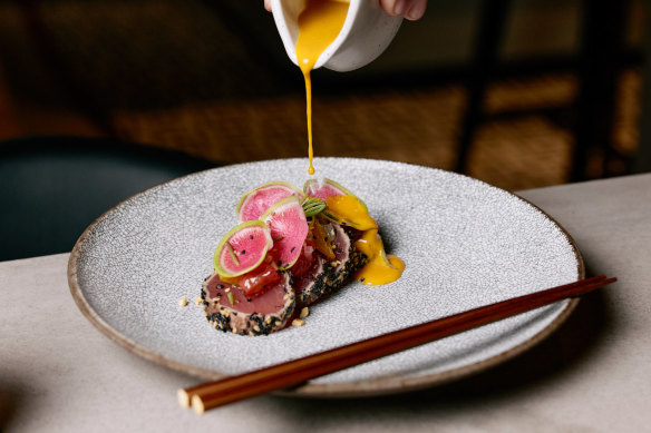 Yellowfin tuna tiradito with citrus, sesame, peanut, aji mirisol and radish.