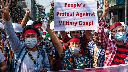 People make three-finger salutes during an anti-coup march.