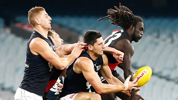 In the thick of it: Carlton's Marc Pittonet scraps in the pack against Bomber Anthony McDonald-Tipungwutii.