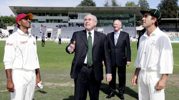 Former PM John Howard tosses the coin before a match.