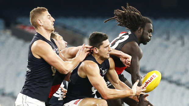 In the thick of it: Carlton's Marc Pittonet scraps in the pack against Bomber Anthony McDonald-Tipungwutii.