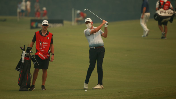 New Zealand golfer Ryan Chisnall wears a mask as thick smoke blanketed The Australian Golf Club during the opening round of the Australian Open on Thursday.