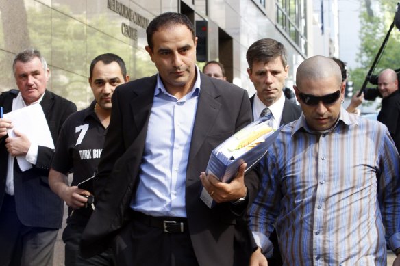 Rob Karam (centre) carrying a blue folder, outside Melbourne Magistrates Court in 2009.