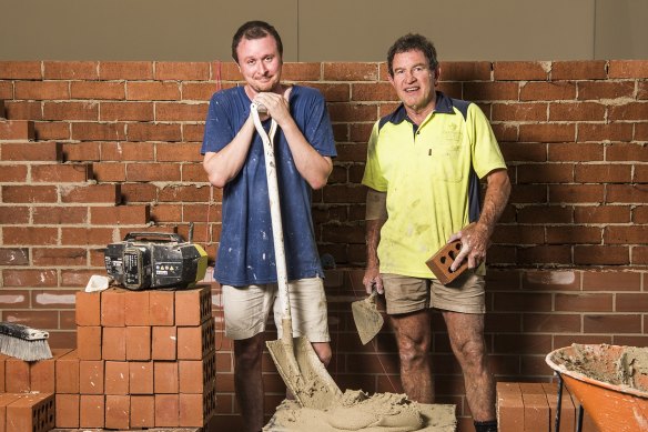 Artist Mitch Cairns building a red brick wall with his bricklayer father, David, at Carriageworks.
