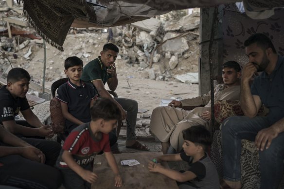 Palestinians sit inside a makeshift tent they built in the rubble of their home, destroyed by an air strike in Beit Lahia, in the northern Gaza Strip, in June. 