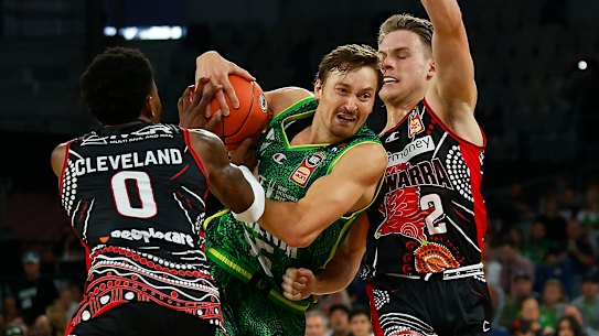 MELBOURNE, AUSTRALIA - MARCH 06: Ryan Broekhoff of the Phoenix drives to the basket under pressure from Antonius Cleveland of the Hawks (L) and Isaac White of the Hawks during the round 16 NBL match between South East Melbourne Phoenix and Illawarra Hawks at John Cain Arena on March 06, 2022, in Melbourne, Australia. (Photo by Daniel Pockett/Getty Images)