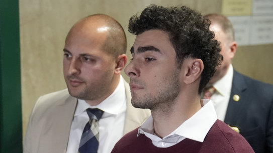 Luigi Mangione, center, is escorted from Manhattan Criminal Court after his arraignment where he pled not guilty to state murder and terror charges in the killing of UnitedHealthcare CEO Brian Thompson.